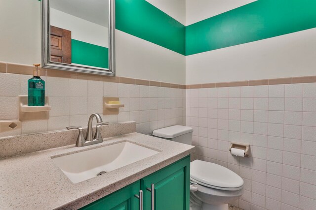 bathroom featuring vanity, toilet, and tile walls