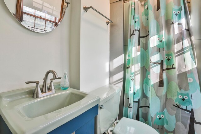 bathroom featuring vanity, toilet, and a healthy amount of sunlight