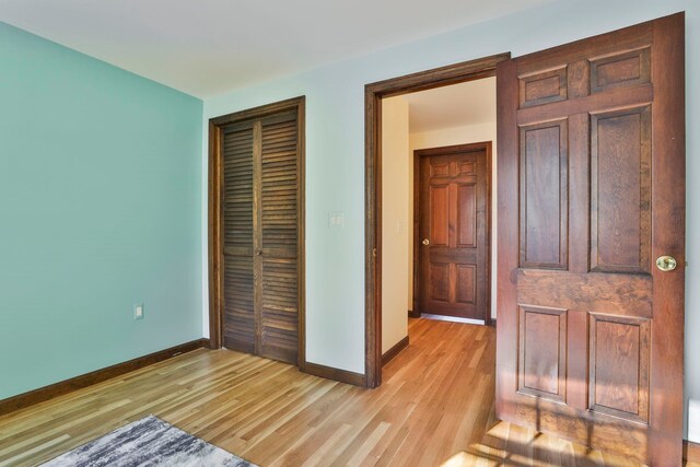 unfurnished bedroom with light hardwood / wood-style floors and a closet