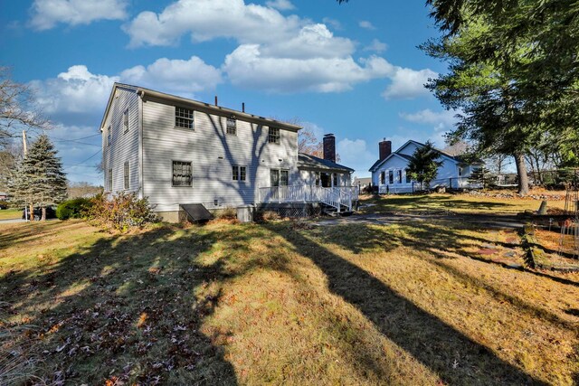 rear view of house featuring a lawn and a deck