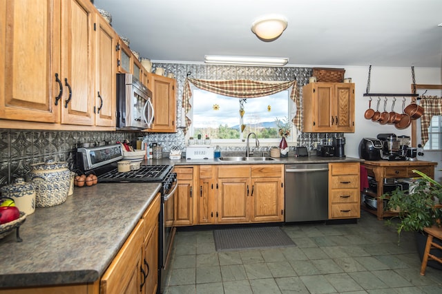 kitchen featuring backsplash, sink, ornamental molding, and appliances with stainless steel finishes