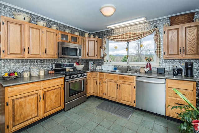 kitchen featuring appliances with stainless steel finishes, tasteful backsplash, crown molding, and sink