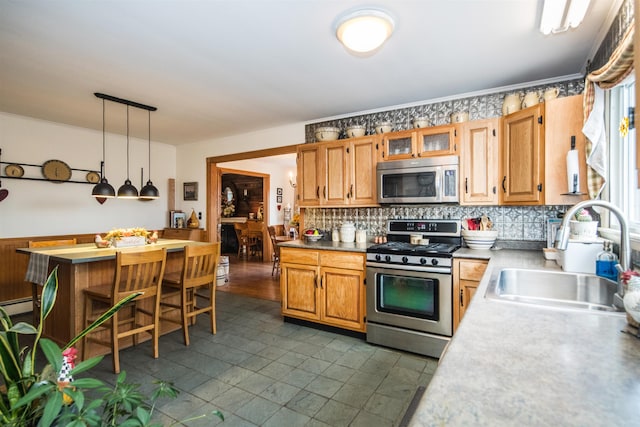 kitchen with sink, hanging light fixtures, stainless steel appliances, backsplash, and a breakfast bar area