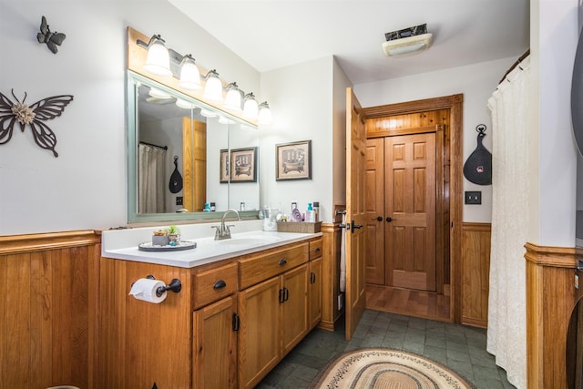 bathroom featuring vanity and wooden walls