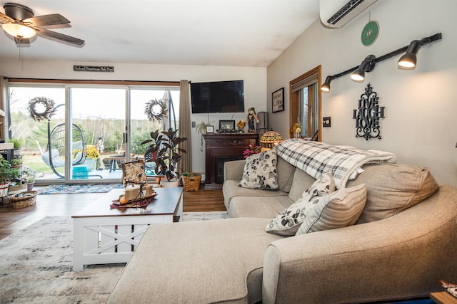 living room with hardwood / wood-style flooring, ceiling fan, and a wall mounted AC