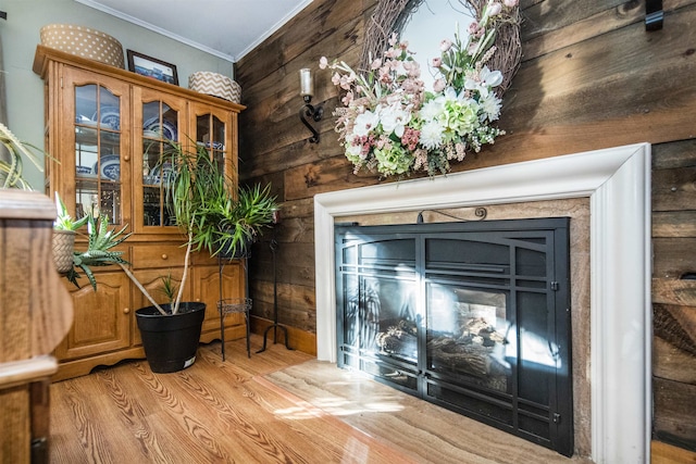 room details with wooden walls, hardwood / wood-style floors, and ornamental molding