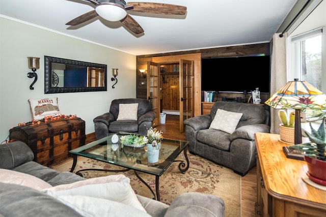 living room featuring hardwood / wood-style flooring, ceiling fan, and crown molding