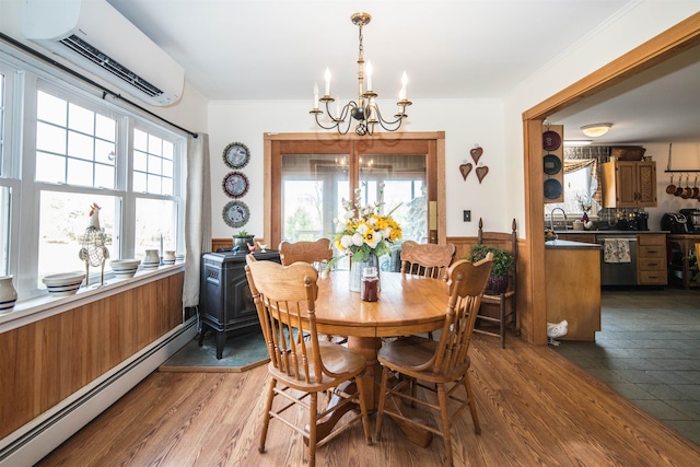 dining space with hardwood / wood-style floors, a chandelier, an AC wall unit, and a baseboard radiator