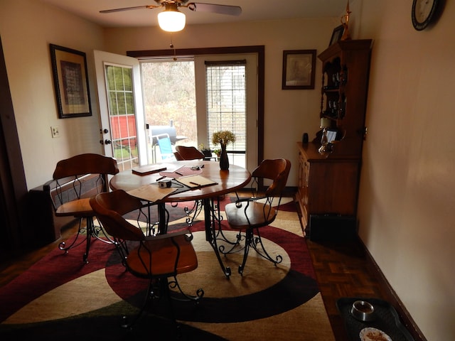 dining space with dark parquet floors and ceiling fan