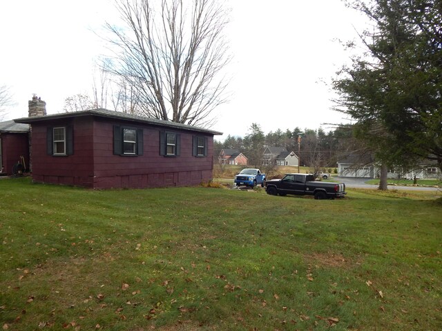 view of side of home with a lawn