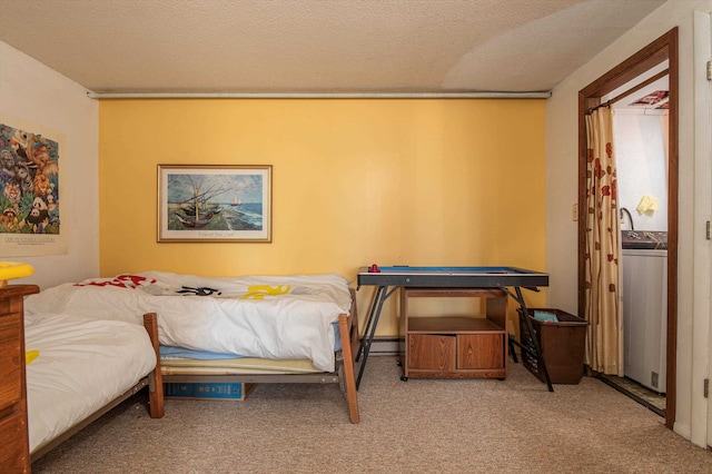 bedroom featuring a textured ceiling, light colored carpet, and washer / clothes dryer