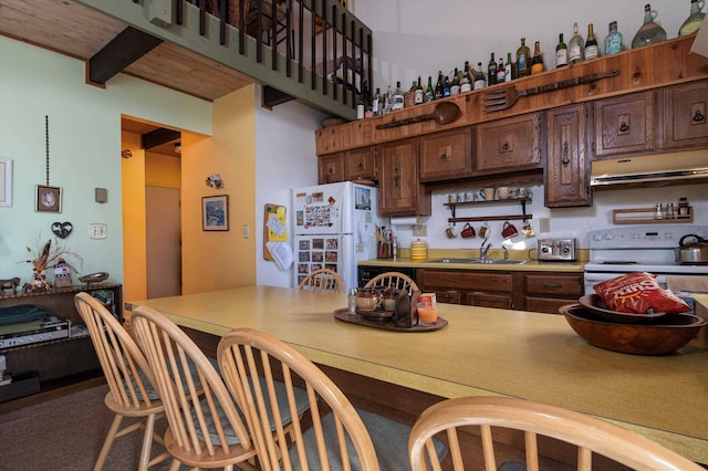 kitchen with white appliances, sink, beam ceiling, dark brown cabinetry, and wood ceiling