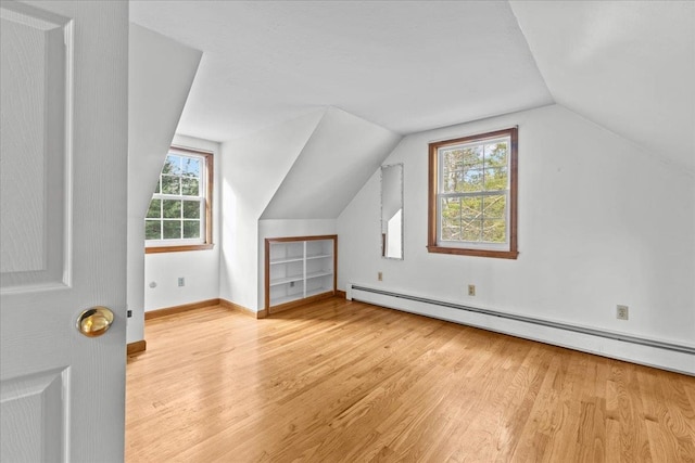 bonus room with baseboard heating, light hardwood / wood-style flooring, and lofted ceiling