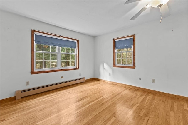 spare room with light hardwood / wood-style floors, ceiling fan, a healthy amount of sunlight, and a baseboard heating unit