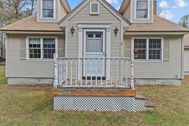 doorway to property with a lawn