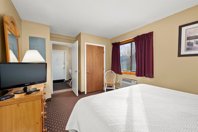 bedroom with a wall mounted air conditioner and dark carpet