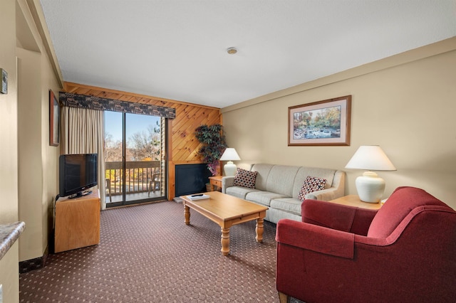 carpeted living room featuring wooden walls