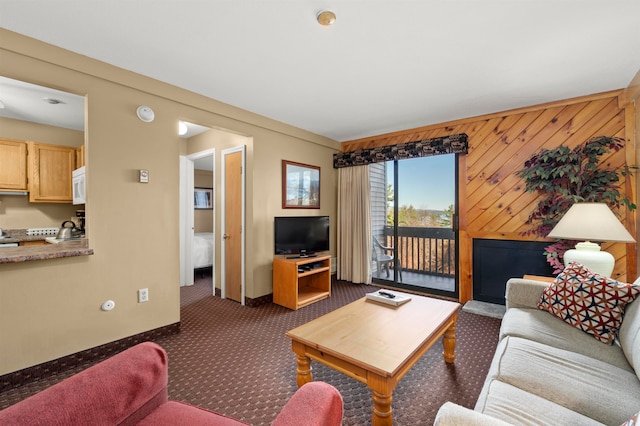 living room with wooden walls and dark carpet