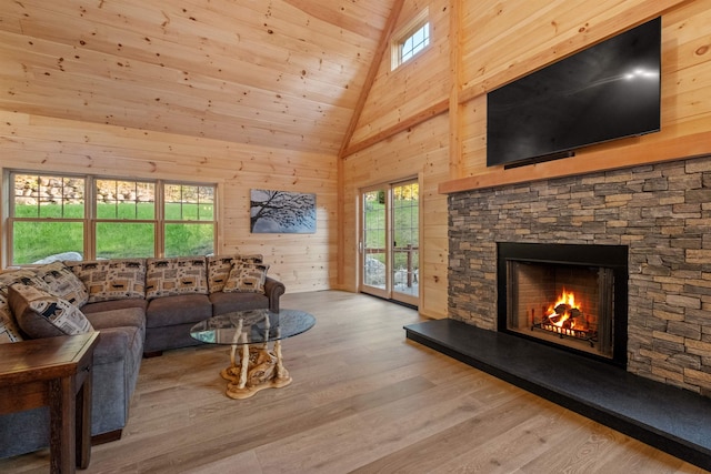 4 Hay Hill Rd, Lincoln, NH 03251 - living room with wood finished floors, wooden walls, a stone fireplace, healthy amount of natural light, and high vaulted ceiling