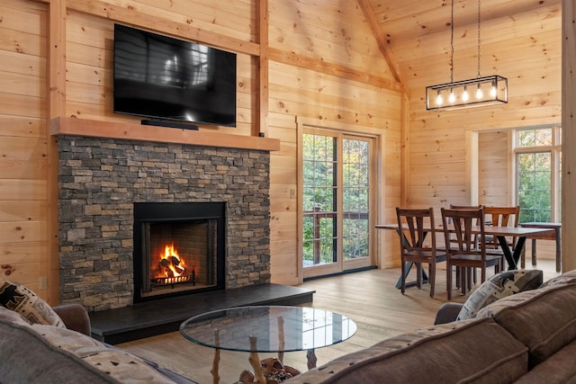 4 Hay Hill Rd, Lincoln, NH 03251 - living area featuring lofted ceiling, wooden walls, wood finished floors, wood ceiling, and a stone fireplace