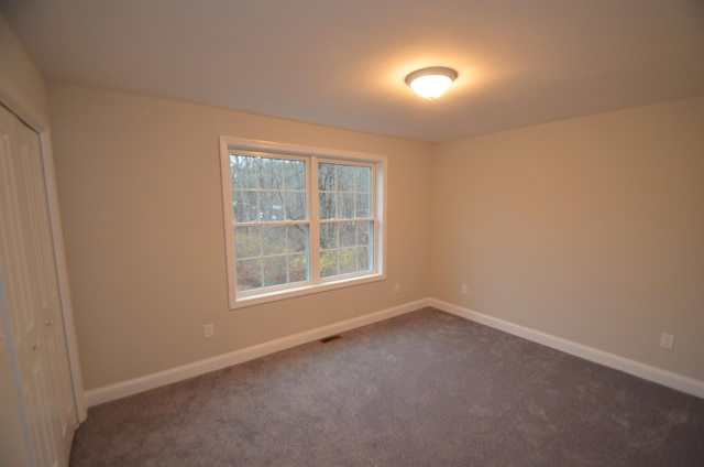 empty room with dark colored carpet