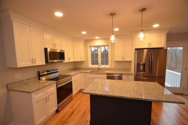 kitchen featuring pendant lighting, a center island, sink, and stainless steel appliances