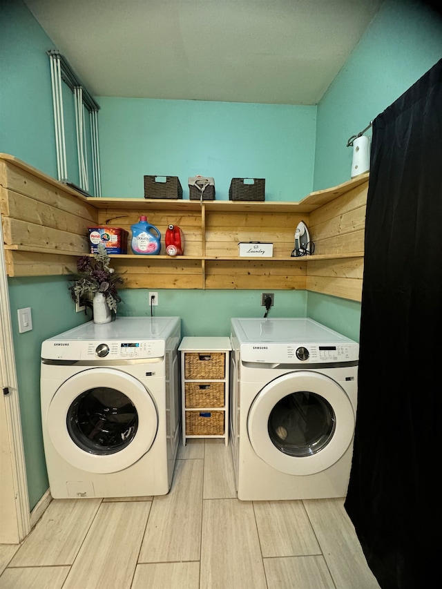 clothes washing area with cabinets and washer and clothes dryer