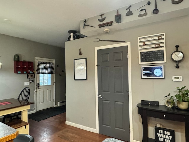 entrance foyer featuring baseboard heating and dark hardwood / wood-style floors