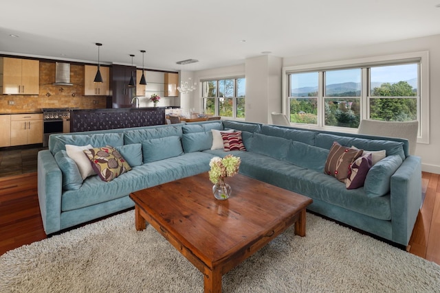 living room with light hardwood / wood-style flooring, a healthy amount of sunlight, and sink