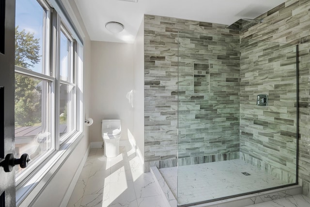 bathroom with a tile shower and toilet