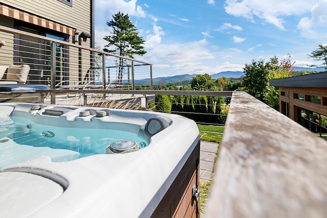 view of swimming pool with a mountain view and a hot tub