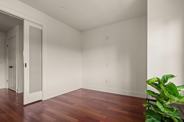 unfurnished room with dark hardwood / wood-style flooring