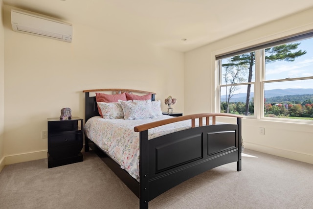 bedroom with an AC wall unit, a mountain view, and light colored carpet