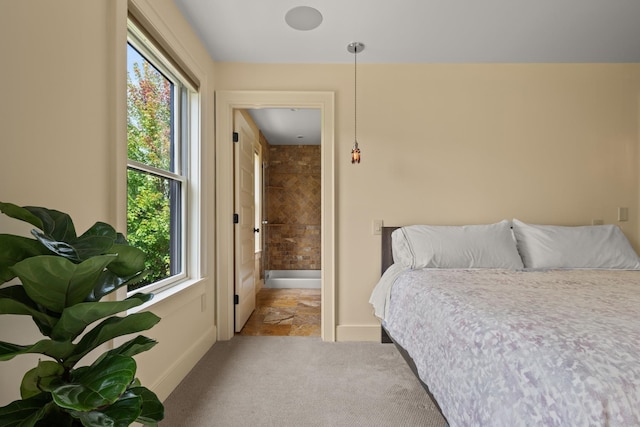 bedroom with connected bathroom and multiple windows