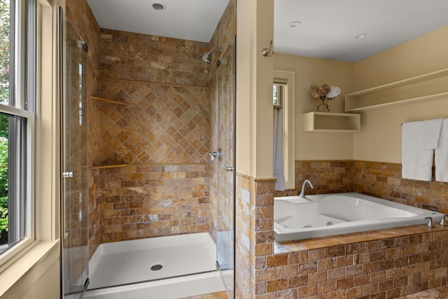 bathroom with a healthy amount of sunlight and separate shower and tub