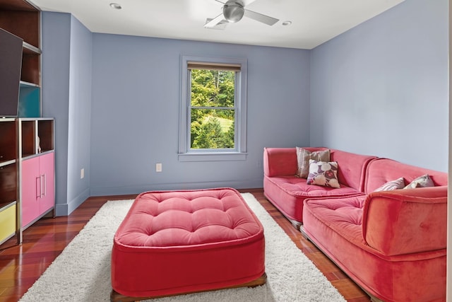 living room featuring ceiling fan and dark hardwood / wood-style flooring