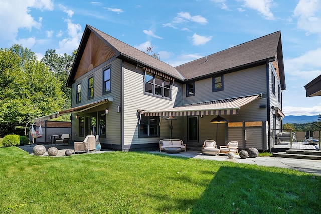 rear view of house featuring a lawn, an outdoor living space, and a patio