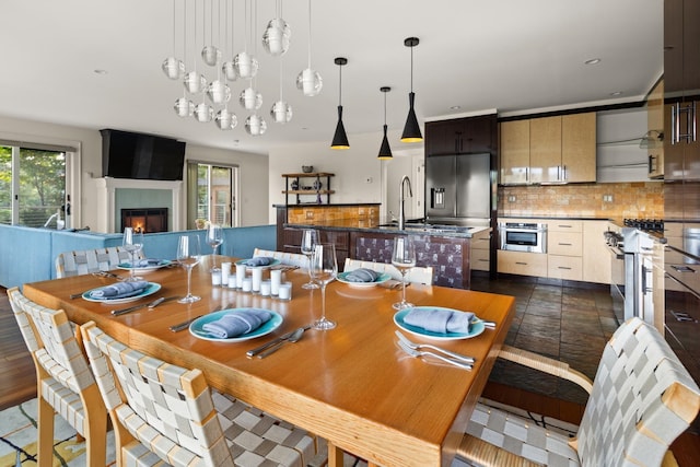 dining space with a large fireplace, dark hardwood / wood-style flooring, and sink