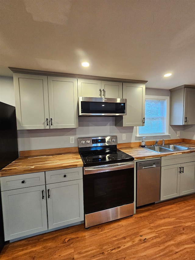 kitchen featuring sink, light hardwood / wood-style flooring, appliances with stainless steel finishes, and wooden counters