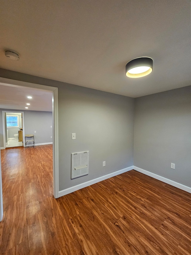 empty room featuring hardwood / wood-style flooring and heating unit