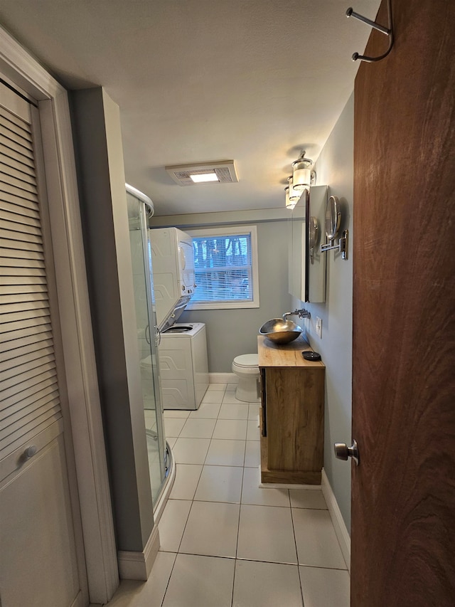 bathroom with vanity, tile patterned flooring, toilet, walk in shower, and washer / dryer