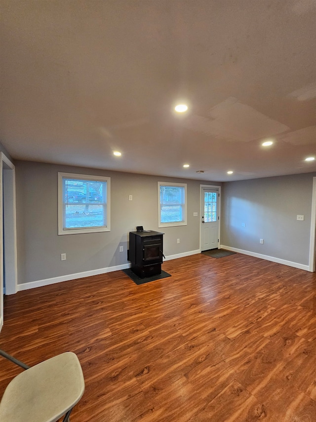 unfurnished living room featuring hardwood / wood-style floors and a wood stove