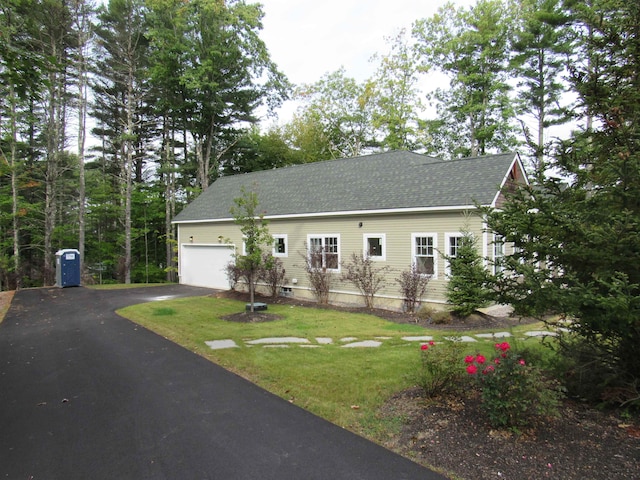 view of front of property with a garage and a front lawn