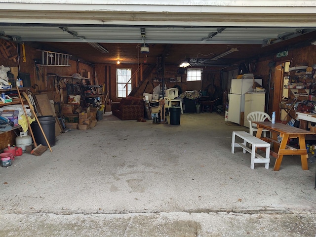 garage featuring white fridge and a garage door opener