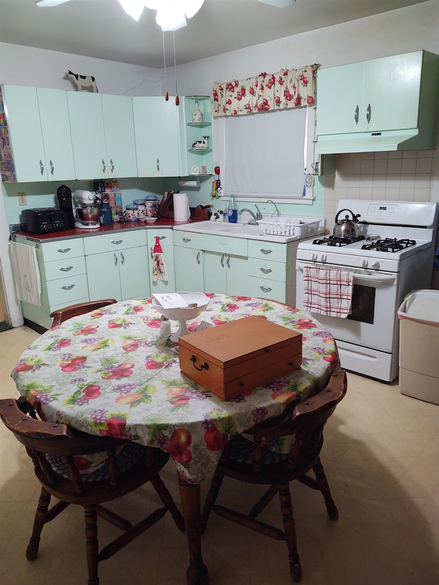 kitchen featuring white range with gas stovetop and backsplash