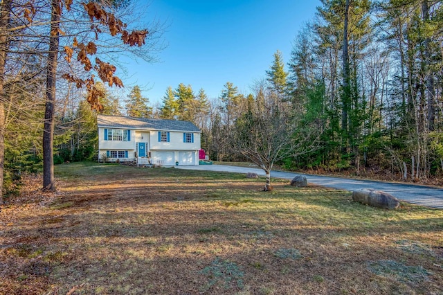 bi-level home featuring a garage and a front lawn