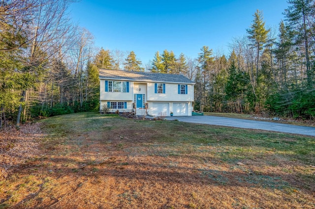 raised ranch with a garage and a front yard