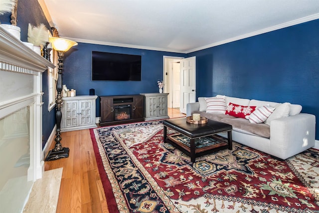 living room featuring hardwood / wood-style floors, crown molding, and a high end fireplace