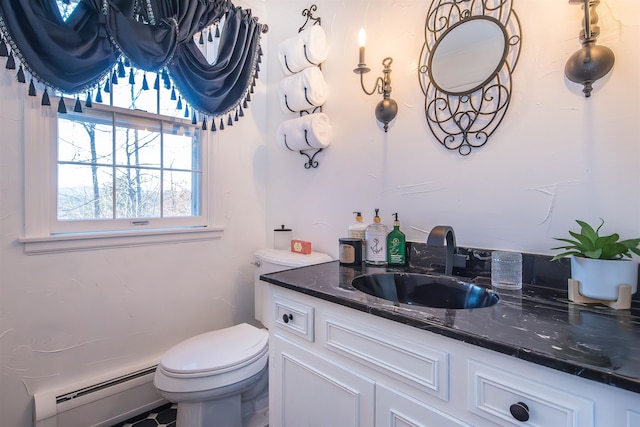 bathroom featuring toilet, vanity, and a baseboard heating unit