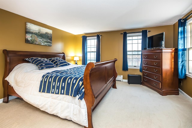 bedroom with baseboard heating and light colored carpet